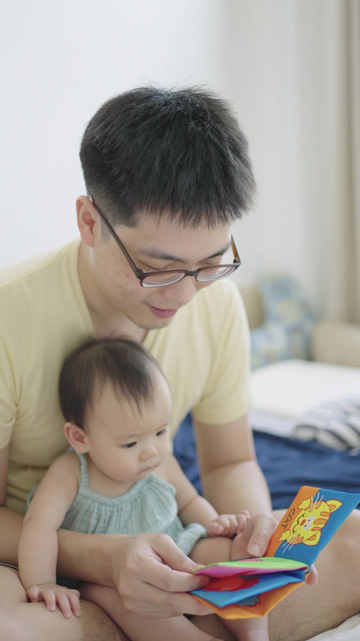 详情图-垂直亚洲年轻的父亲阅读儿童书籍与他的女儿