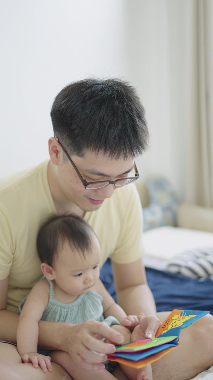 详情图-垂直亚洲年轻的父亲阅读儿童书籍与他的女儿