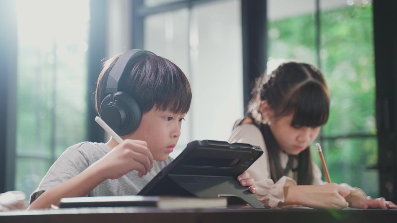 詳情圖-由于冠狀病毒大流行，亞洲小女孩通過數(shù)字遠(yuǎn)程互聯(lián)網(wǎng)會(huì)議從學(xué)校老師那里學(xué)習(xí)在線課程。孩子看著電腦筆記本電腦屏幕，那個(gè)女人在教書。