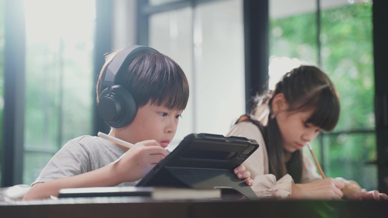 詳情圖-由于冠狀病毒大流行，亞洲小女孩通過數(shù)字遠(yuǎn)程互聯(lián)網(wǎng)會(huì)議從學(xué)校老師那里學(xué)習(xí)在線課程。孩子看著電腦筆記本電腦屏幕，那個(gè)女人在教書。