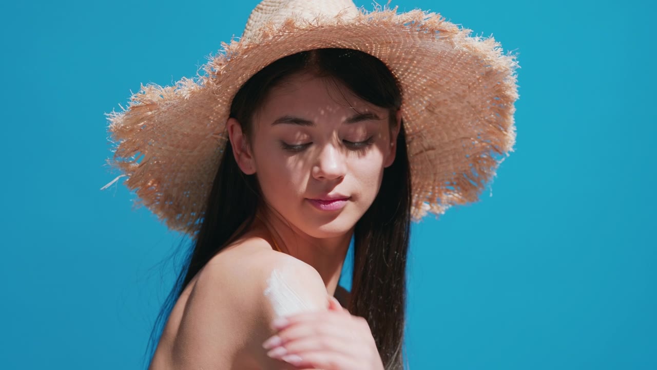 詳情圖-一名年輕女子把防曬霜涂在肩膀上，對著鏡頭微笑
