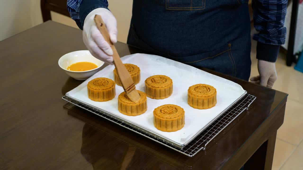 人在烘烤前将蛋液刷在月饼表面