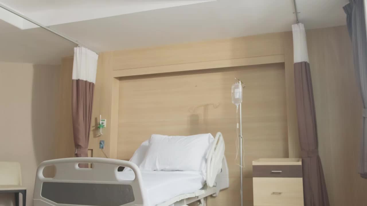 亚洲擦洗制服护士照顾女孩小孩病人坐在轮椅上在医院恢复室。年轻妇女和儿童佩戴外科口罩以预防covid - 19大流行。
