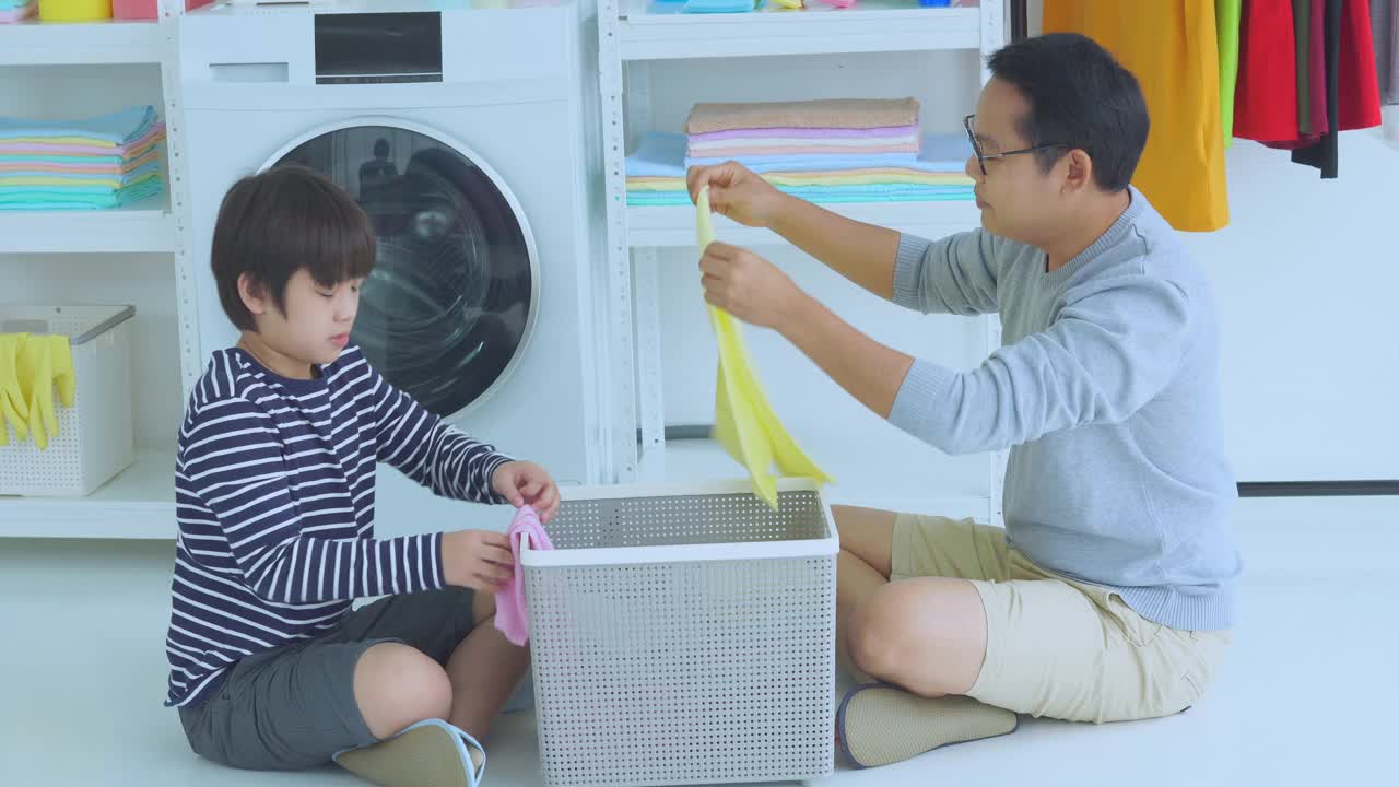 一个男孩和他的父亲在一起做家务以防止病毒的传播，他们一起愉快地打扫了家