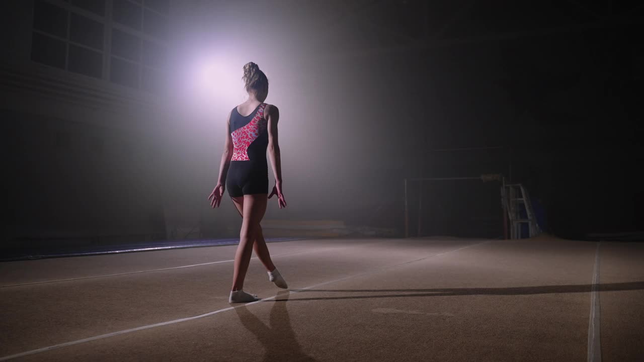 女子体操运动员在弹跳台上表演翻转，在体操馆里单独训练，艺术体操，少年比赛