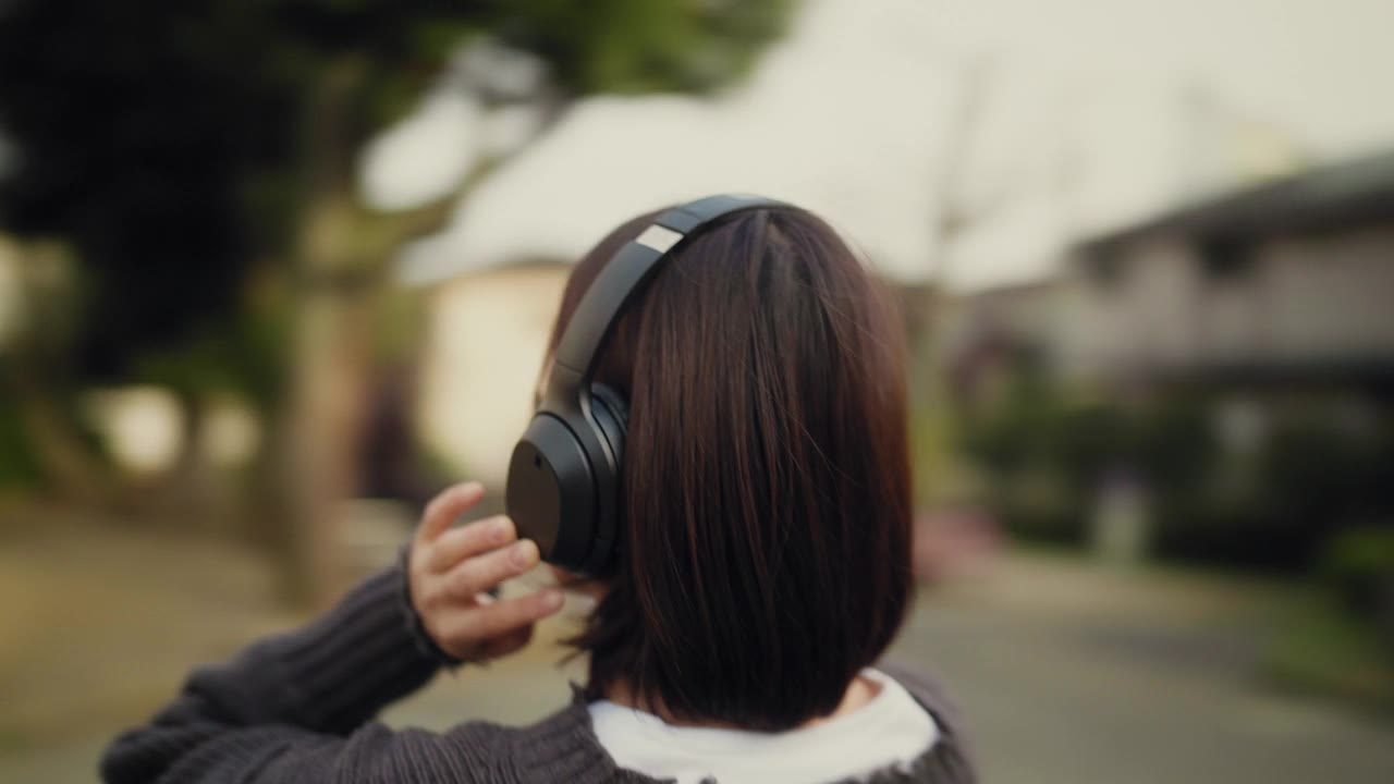 详情图-360度旋转视频肖像年轻女子听音乐在公园