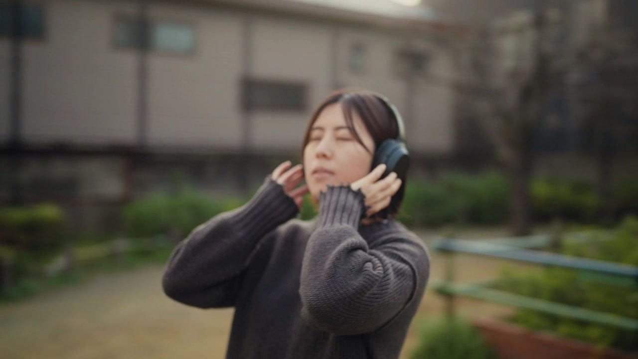 详情图-360度旋转视频肖像年轻女子听音乐在公园