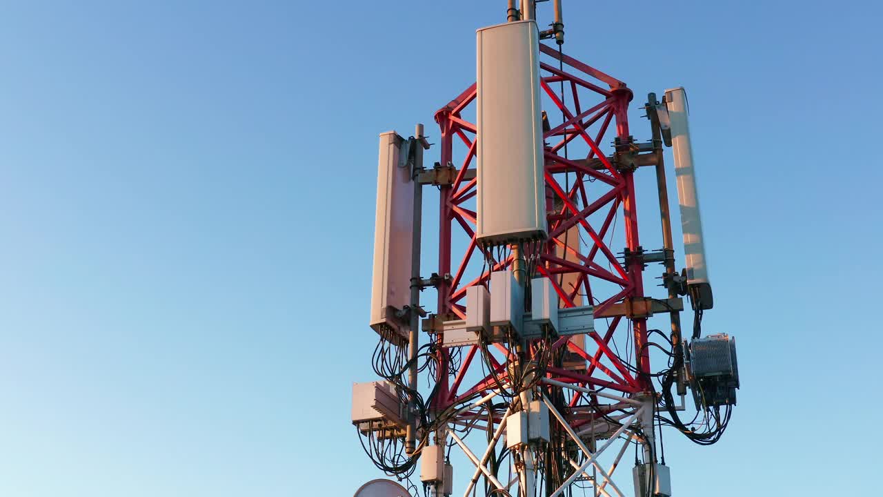 为3G、4G和5G蜂窝网络提供广播天线的电信发射塔。高金属建筑的鸟瞰图，带有移动电话传输和互联网设备。