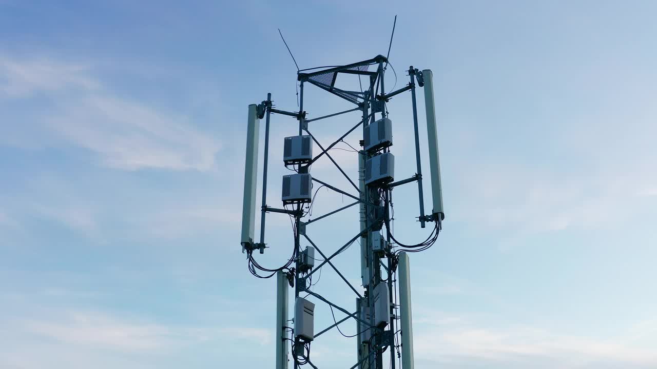 电信发射塔，承载gsm、3G、4G和5G蜂窝网络的广播天线。无人机拍摄的一个高大的金属结构与设备的移动电话和互联网。