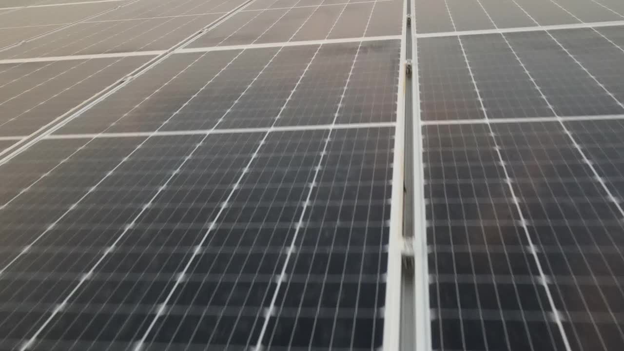 無人機視圖移動真正接近大型太陽能電池板陣列4K鳥瞰圖太陽能電池板農場(太陽能電池)與陽光。