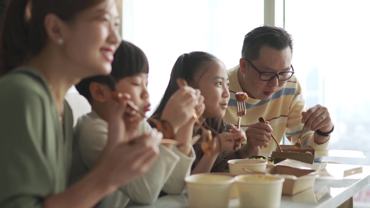 詳情圖-亞洲華人年輕家庭周末在客廳的電視前享受外賣食物