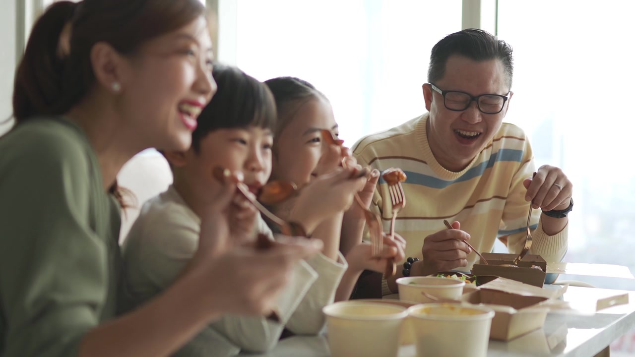 詳情圖-亞洲華人年輕家庭周末在客廳的電視前享受外賣食物