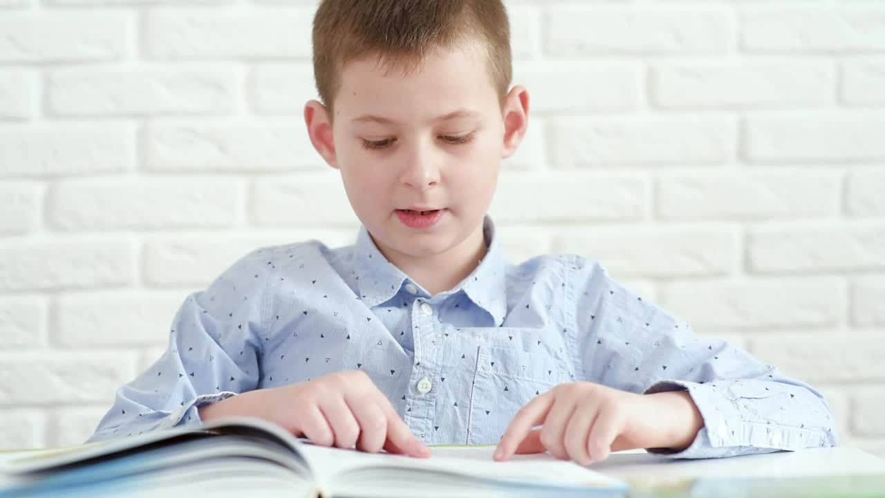 一个小学生坐在一张白色的桌子前看书，桌子的背景是白色的砖