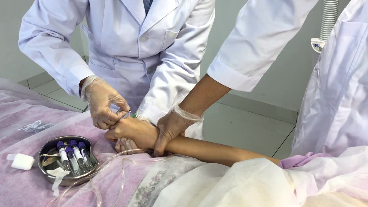 亚洲华人女护士在诊所准备从女性华人病人的手上抽血