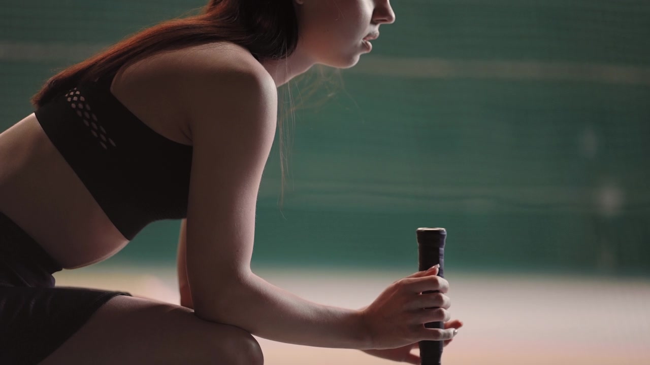 详情图-年轻女子网球运动员的肖像，女运动员正坐在网球场的长椅上，中拍