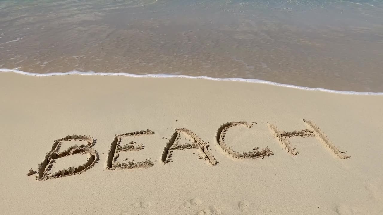 詳情圖-海浪在沙灘上刻下的沙灘銘文是慢動(dòng)作的。假期和假期的概念