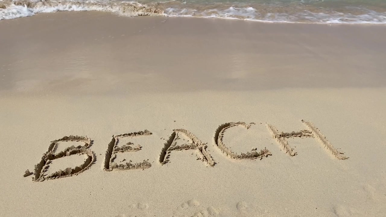 詳情圖-海浪在沙灘上刻下的沙灘銘文是慢動(dòng)作的。假期和假期的概念