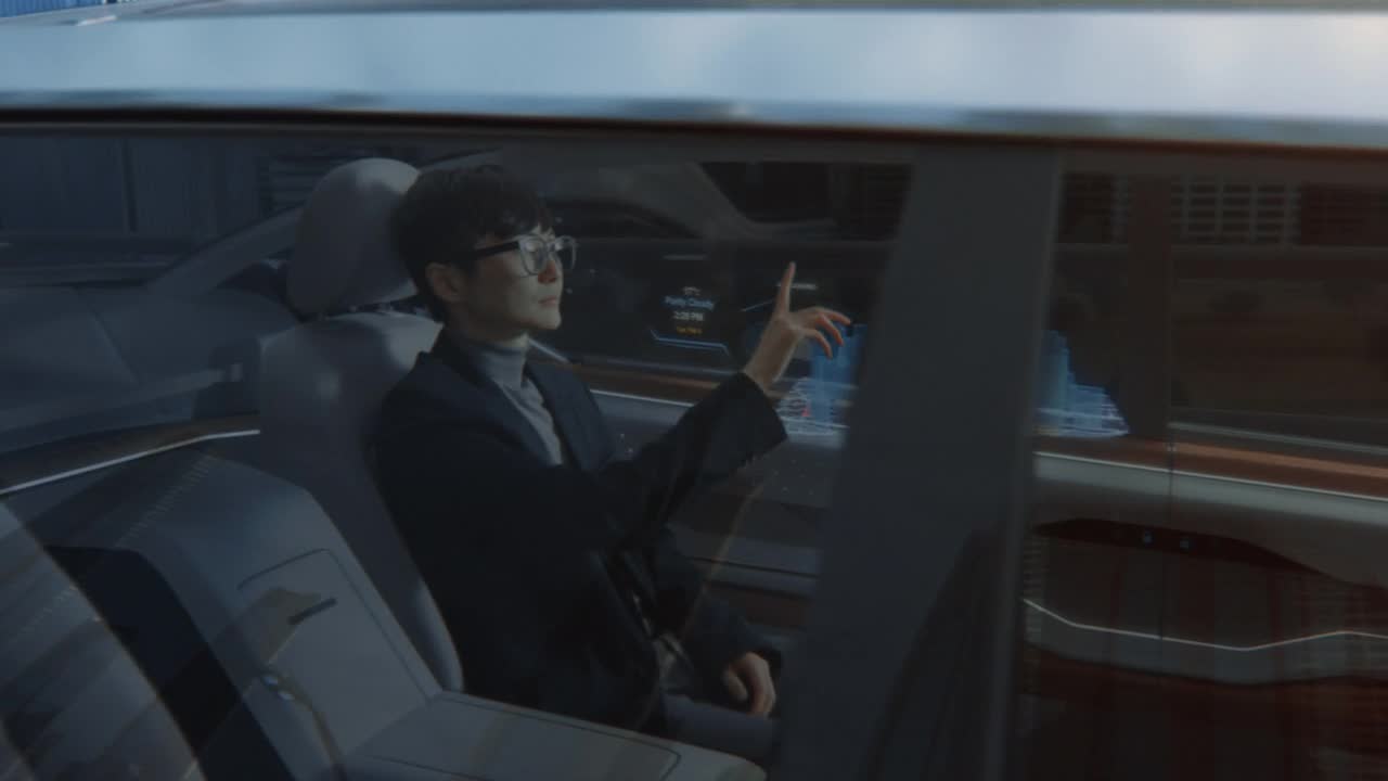 詳情圖-未來主義概念:時(shí)尚的日本商人坐在自動(dòng)駕駛汽車的后座上，在交互式增強(qiáng)現(xiàn)實(shí)3D導(dǎo)航應(yīng)用程序上查看到達(dá)地點(diǎn)。