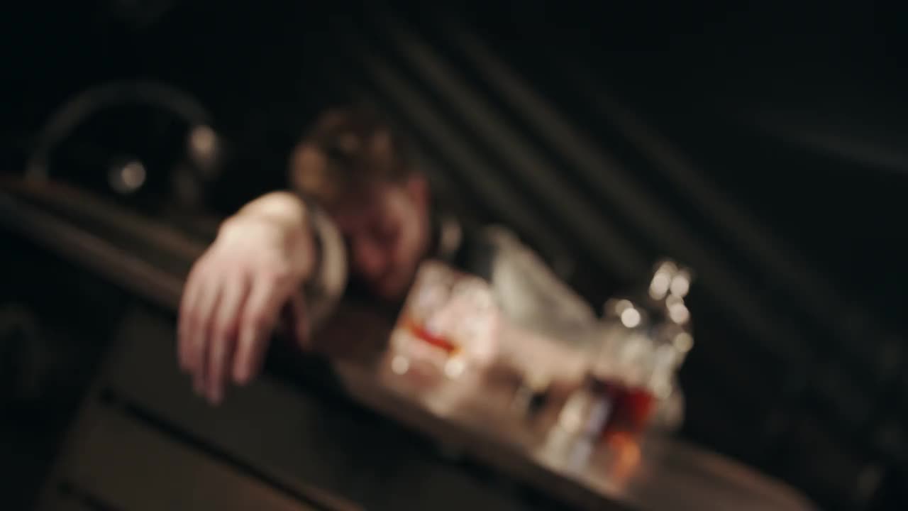 一个醉汉在酒吧里睡着了，醒来后抿了一口威士忌