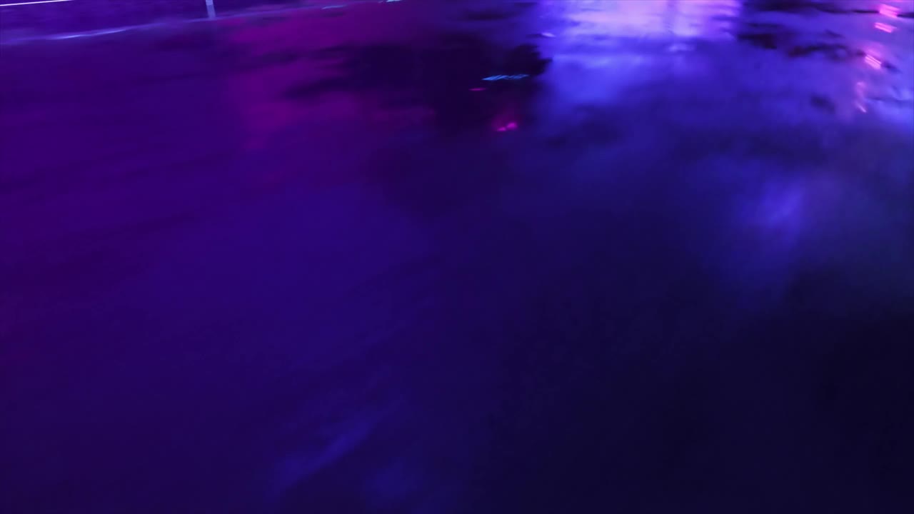 霓虹赛博朋克风格的汽车和城市。80年代retrowave背景3d动画。复古的未来汽车穿过霓虹城市。