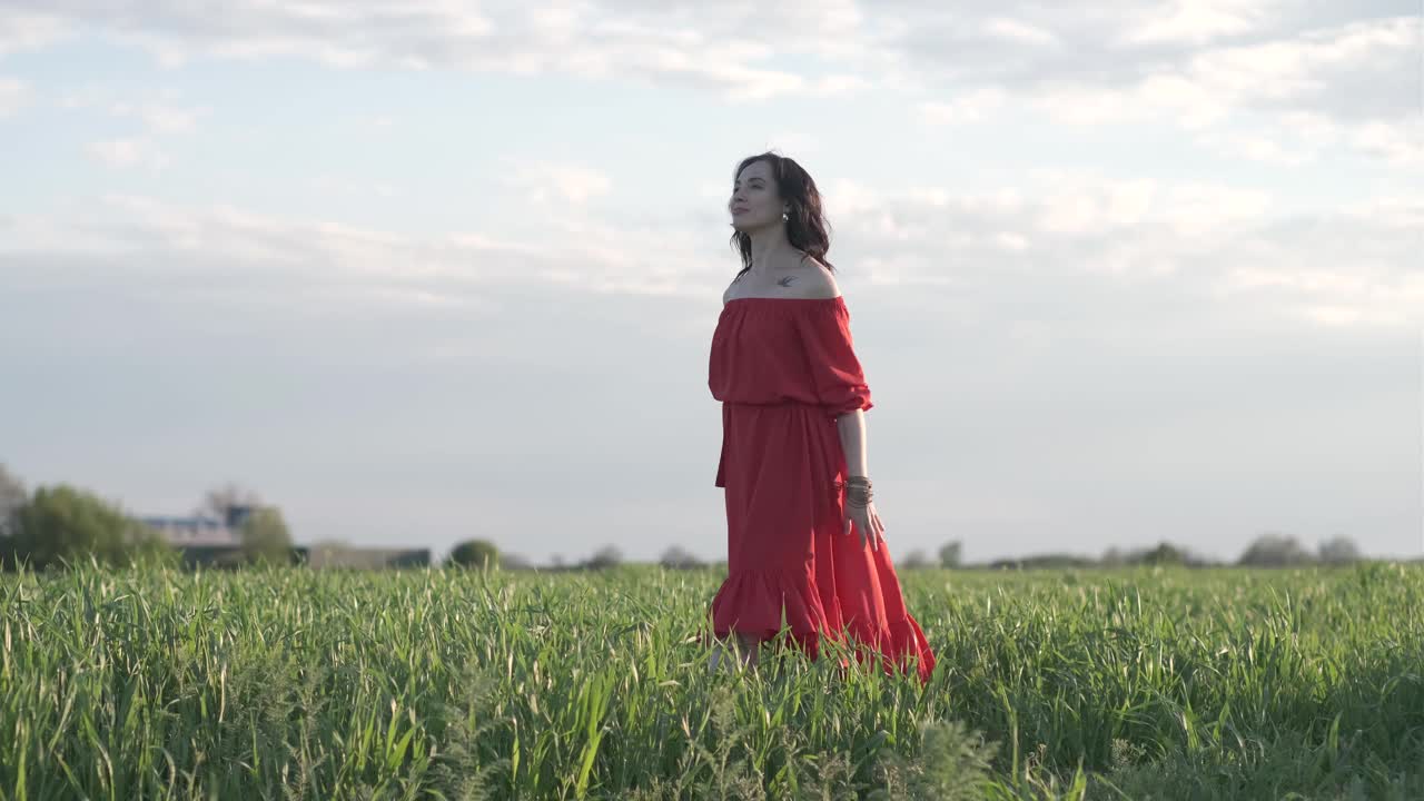 美丽的西班牙年轻女子在夕阳下走在田野里
