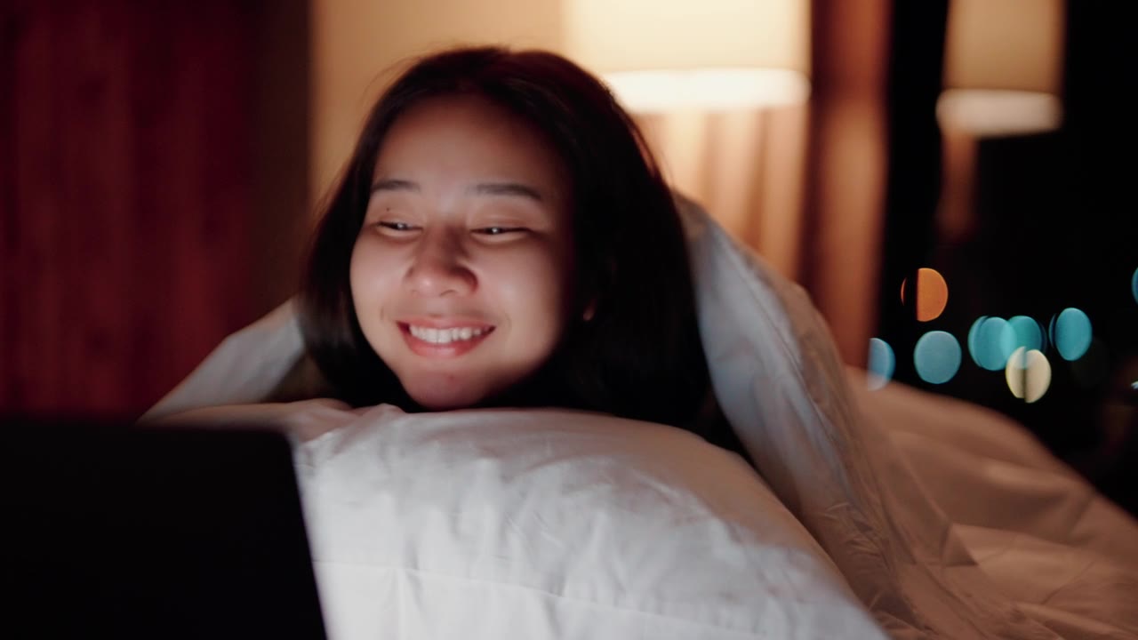 詳情圖-睡眼惺忪的女人在床上看電影。