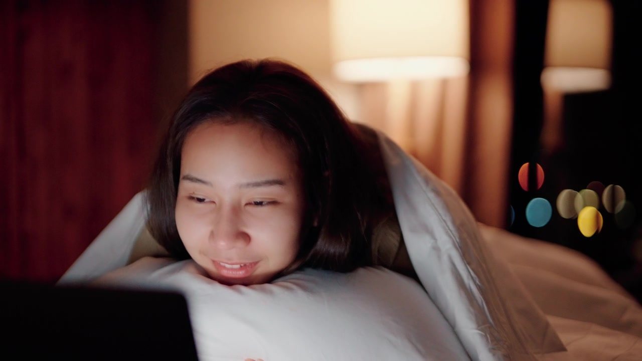 詳情圖-睡眼惺忪的女人在床上看電影。