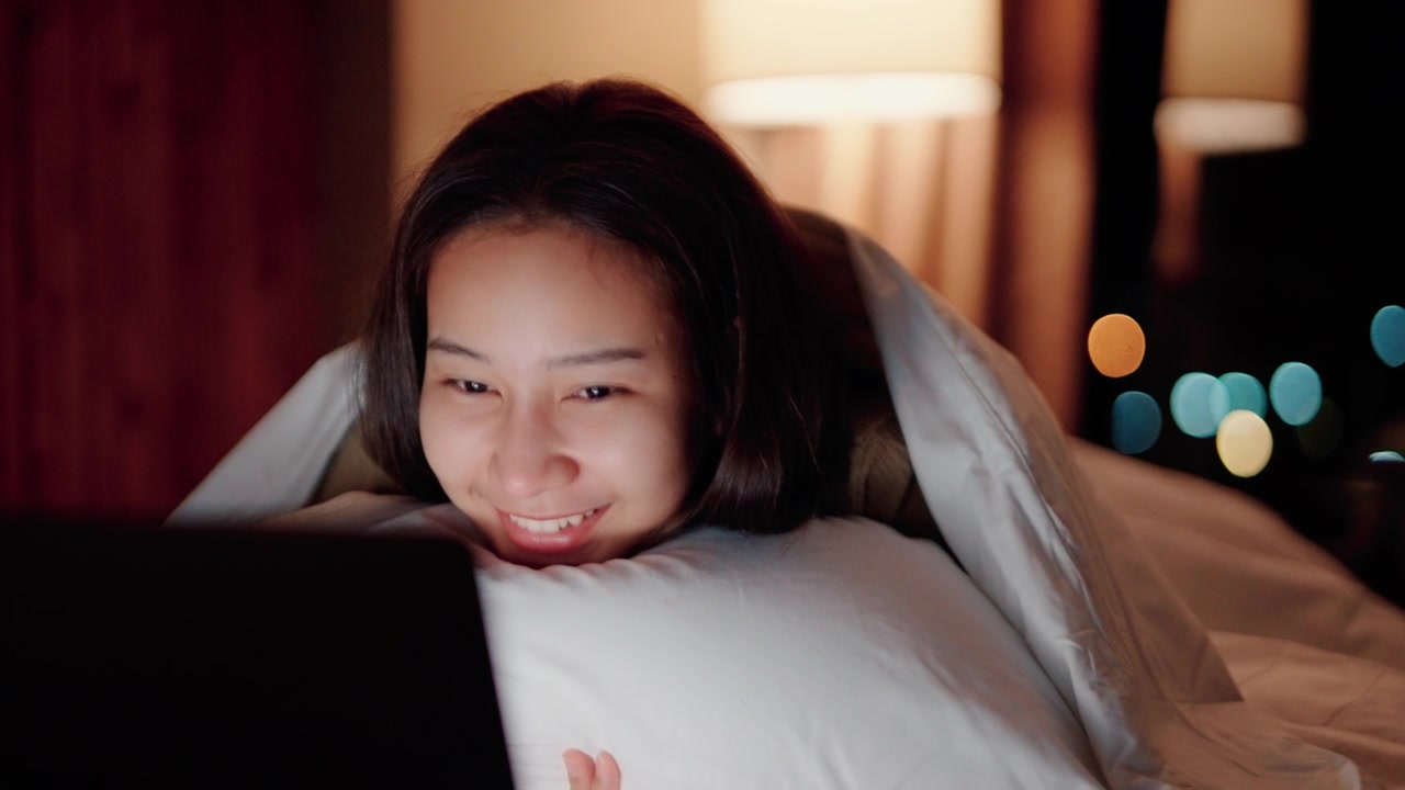 詳情圖-睡眼惺忪的女人在床上看電影。
