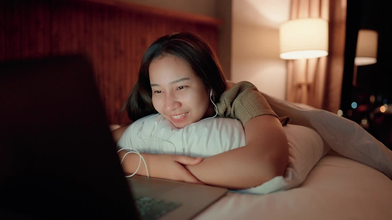 睡眼惺忪的女人半夜在床上上网。