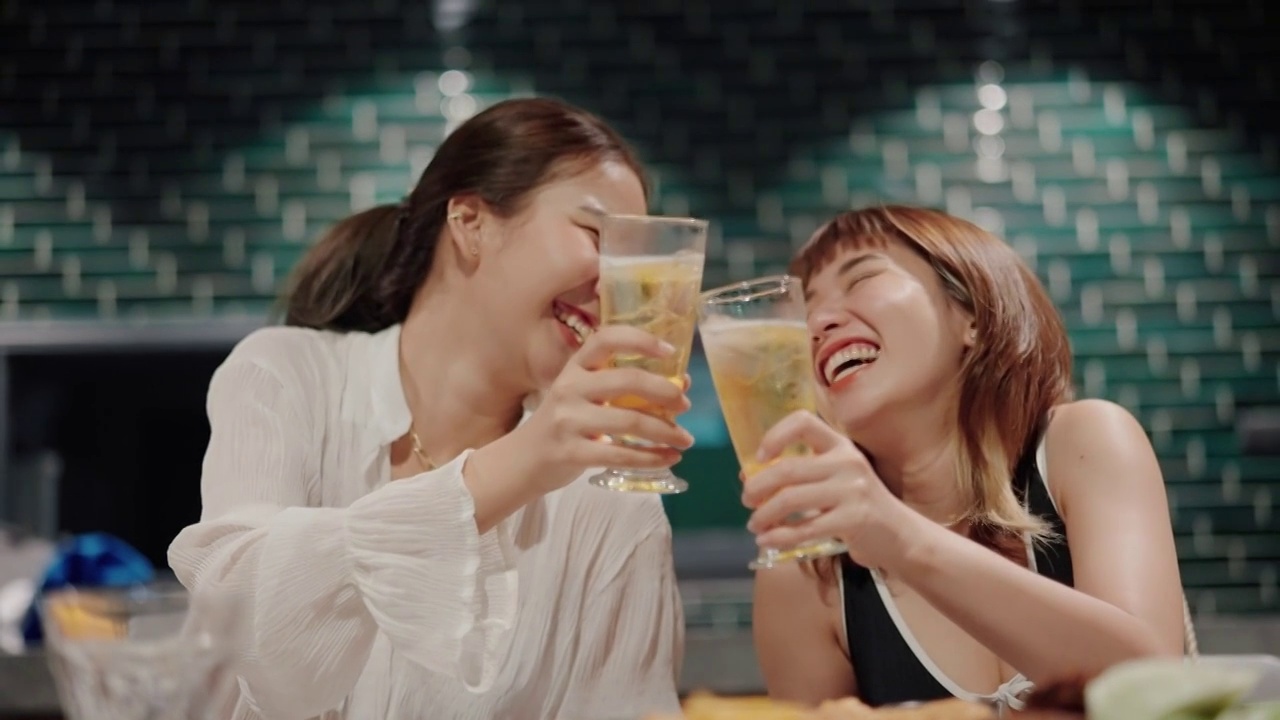 快乐的女人在派对上喝着酒精饮料和她最好的朋友。