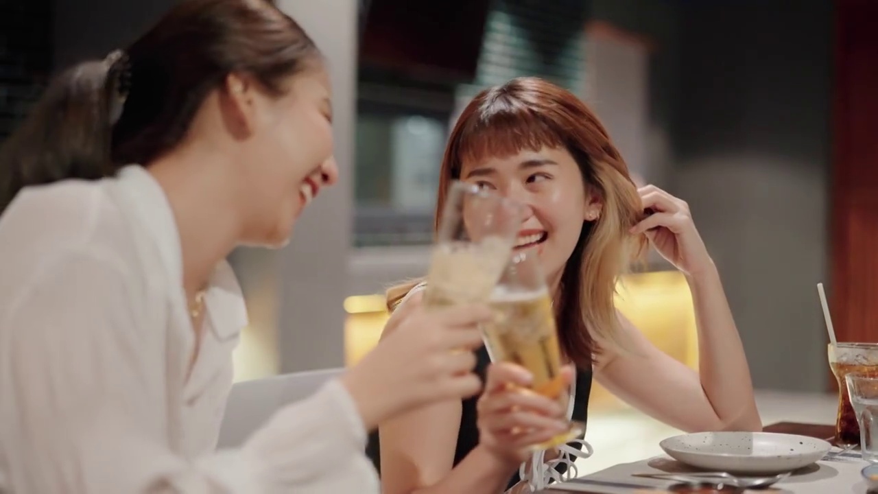 快乐的女人在派对上喝着酒精饮料和她最好的朋友。