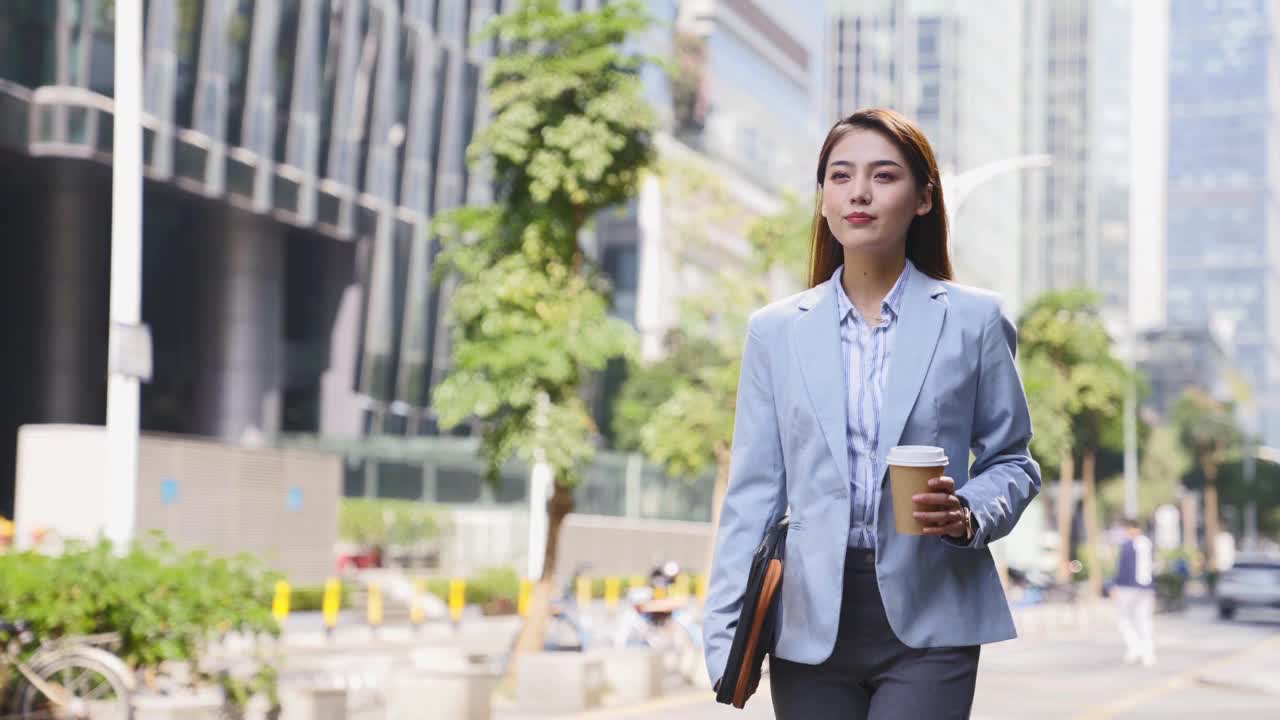年轻的亚洲女商人走在现代城市的中央商务区