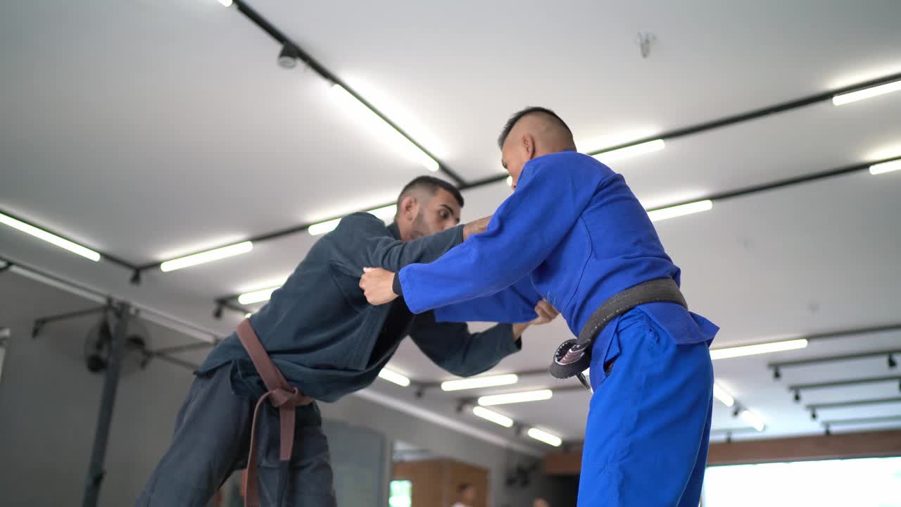 两个男子柔道练习者在体育馆打架