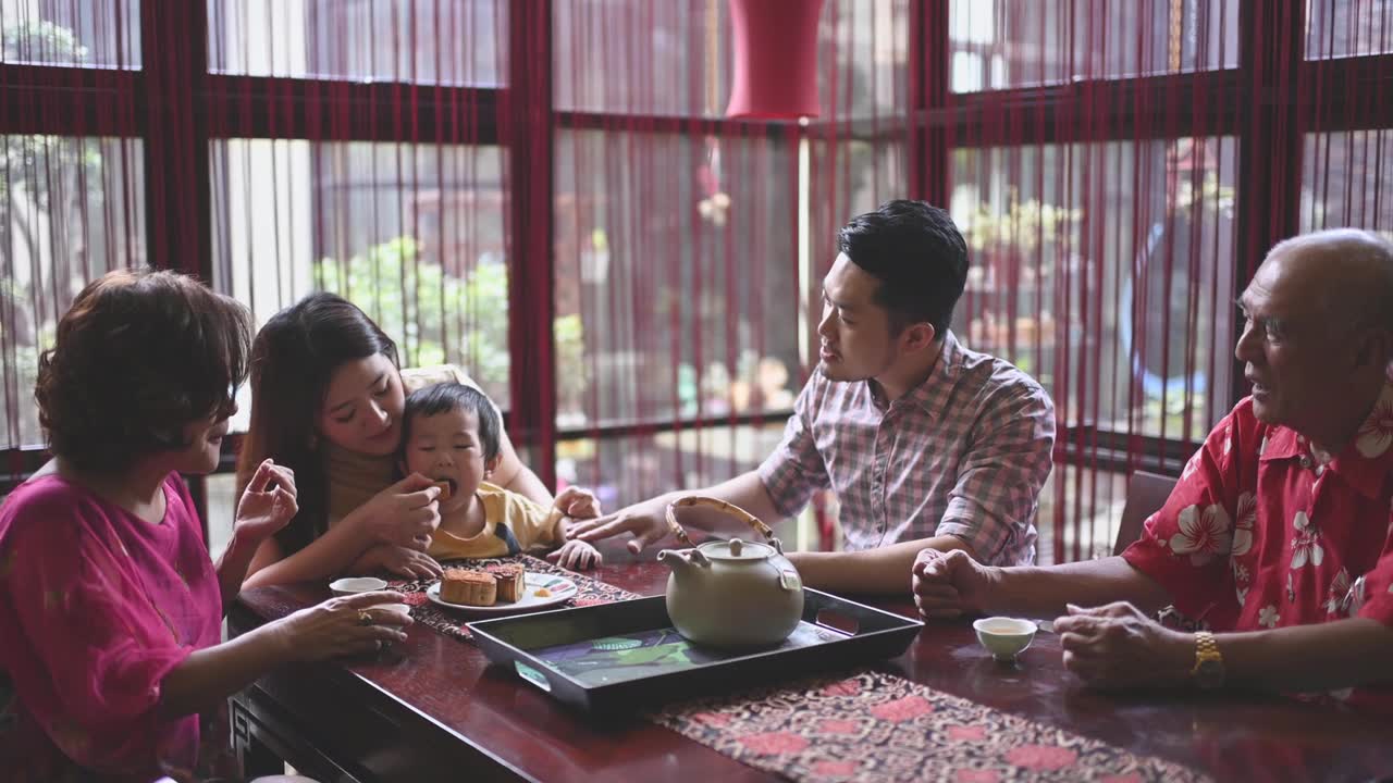 详情图-中国母亲喂养儿子在多代人享受传统中秋节月饼和中国茶在家里下午茶聚会