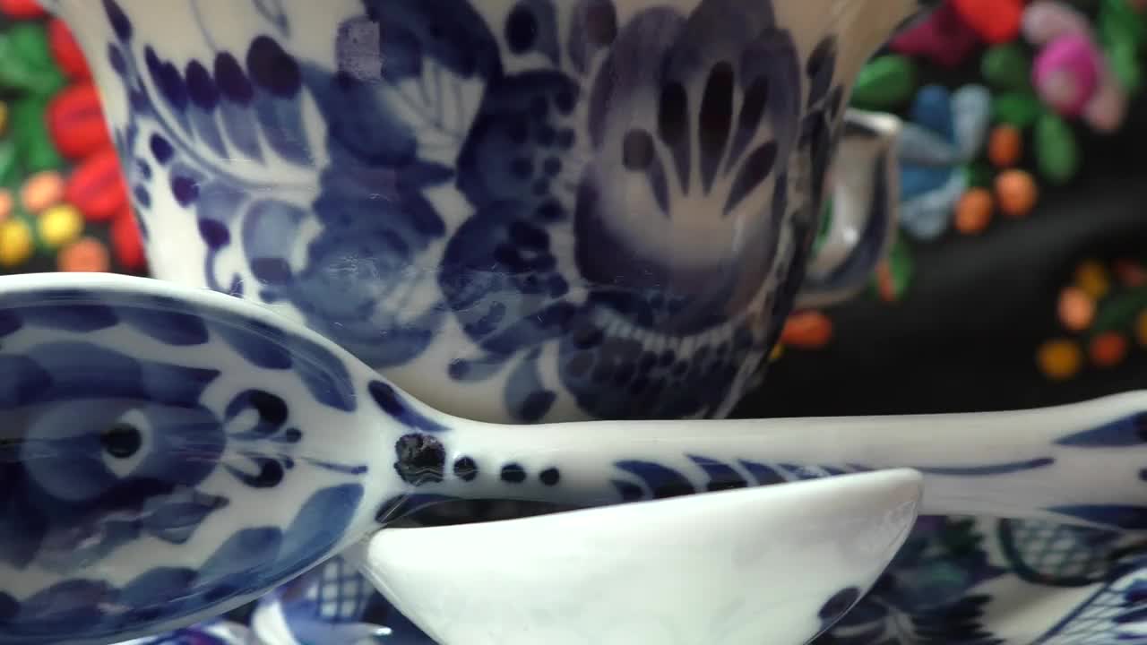 俄罗斯传统格热尔风格的茶杯、茶碟和茶匙。gzel -Russian民间工艺陶瓷和生产瓷器和一种俄罗斯民间绘画。模糊的背景