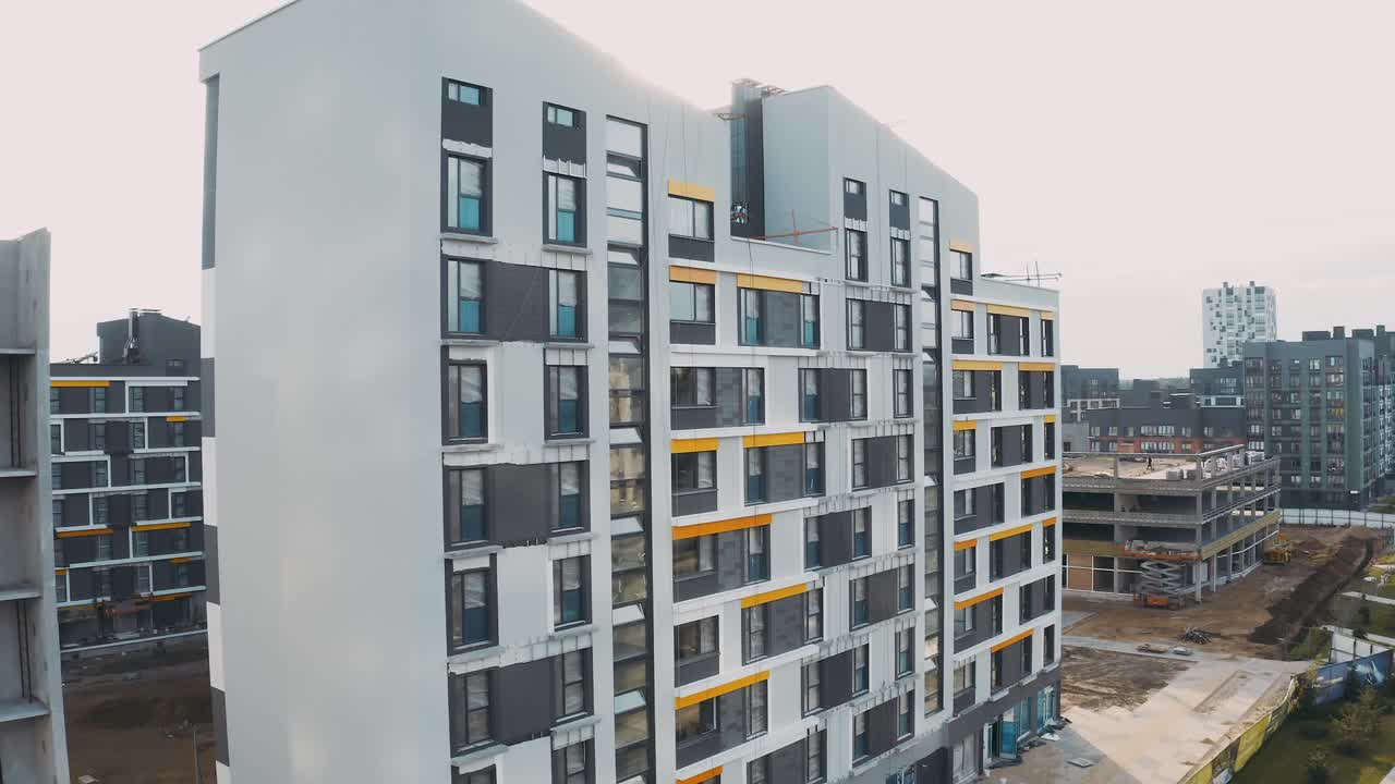 建筑工地，建筑工作过程现代化的公寓板房。未完成结构的城市公寓小区，带有庭院，立面有窗户和复式屋顶，鸟瞰图