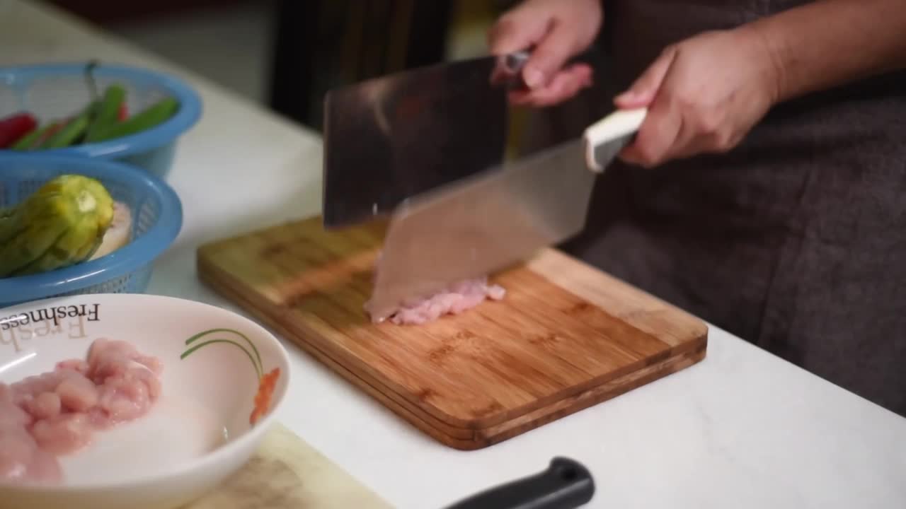 起居室里女人手拿菜刀切肉的高角镜头