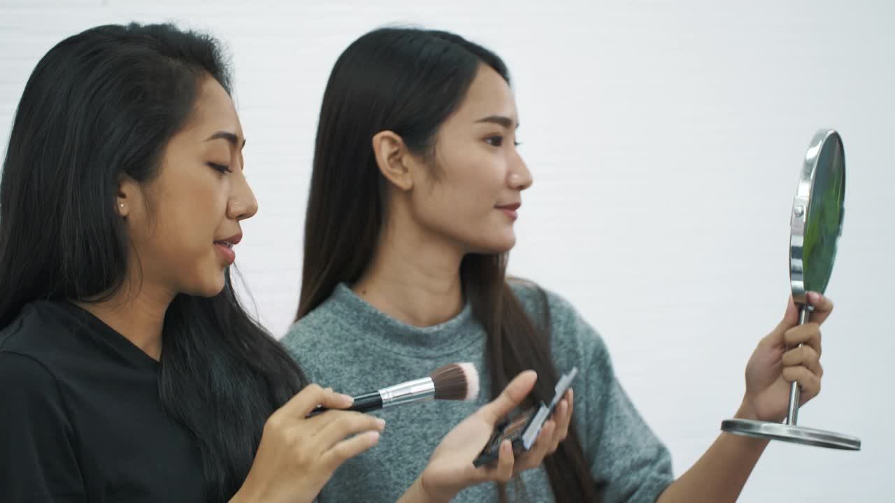 两个亚洲女人在家里化妆