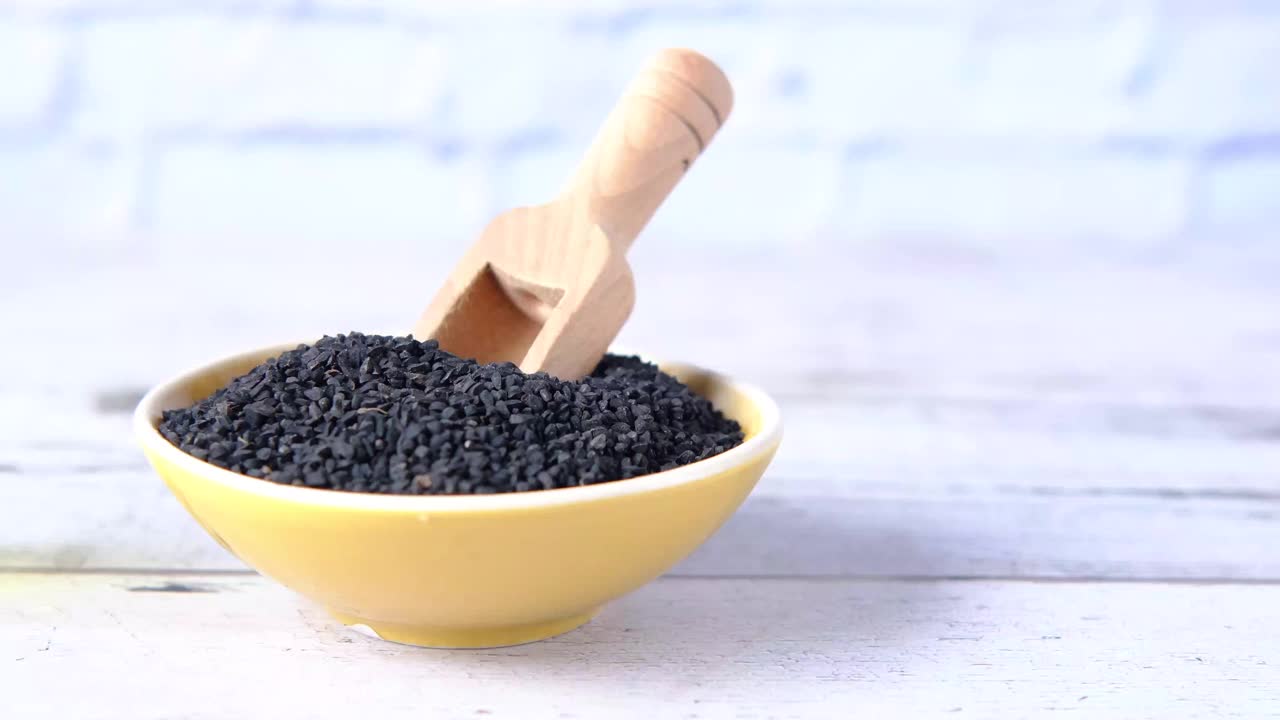 黑孜然装在容器里，油放在桌上的罐子里。