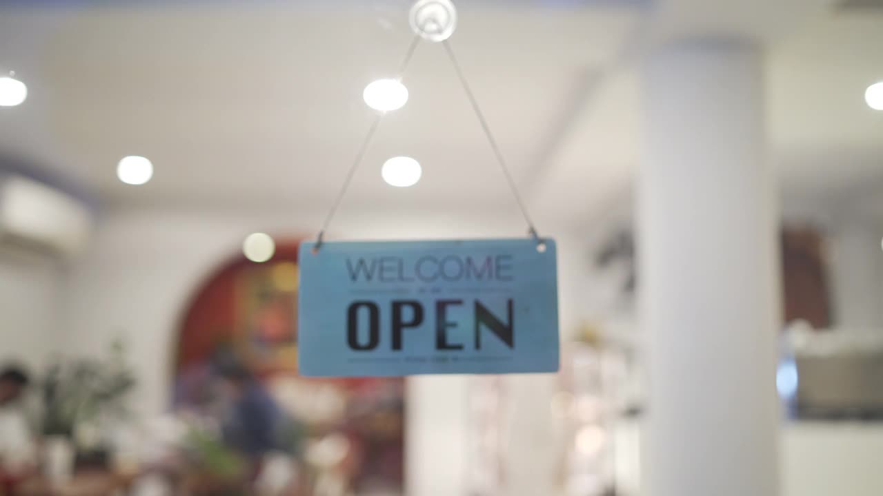 4K亚洲女服务员在咖啡店的门上挂着关门的标志