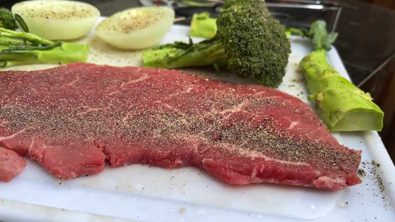 上等调味牛里脊牛排西兰花和洋葱在木炭烧烤与火焰4K视频