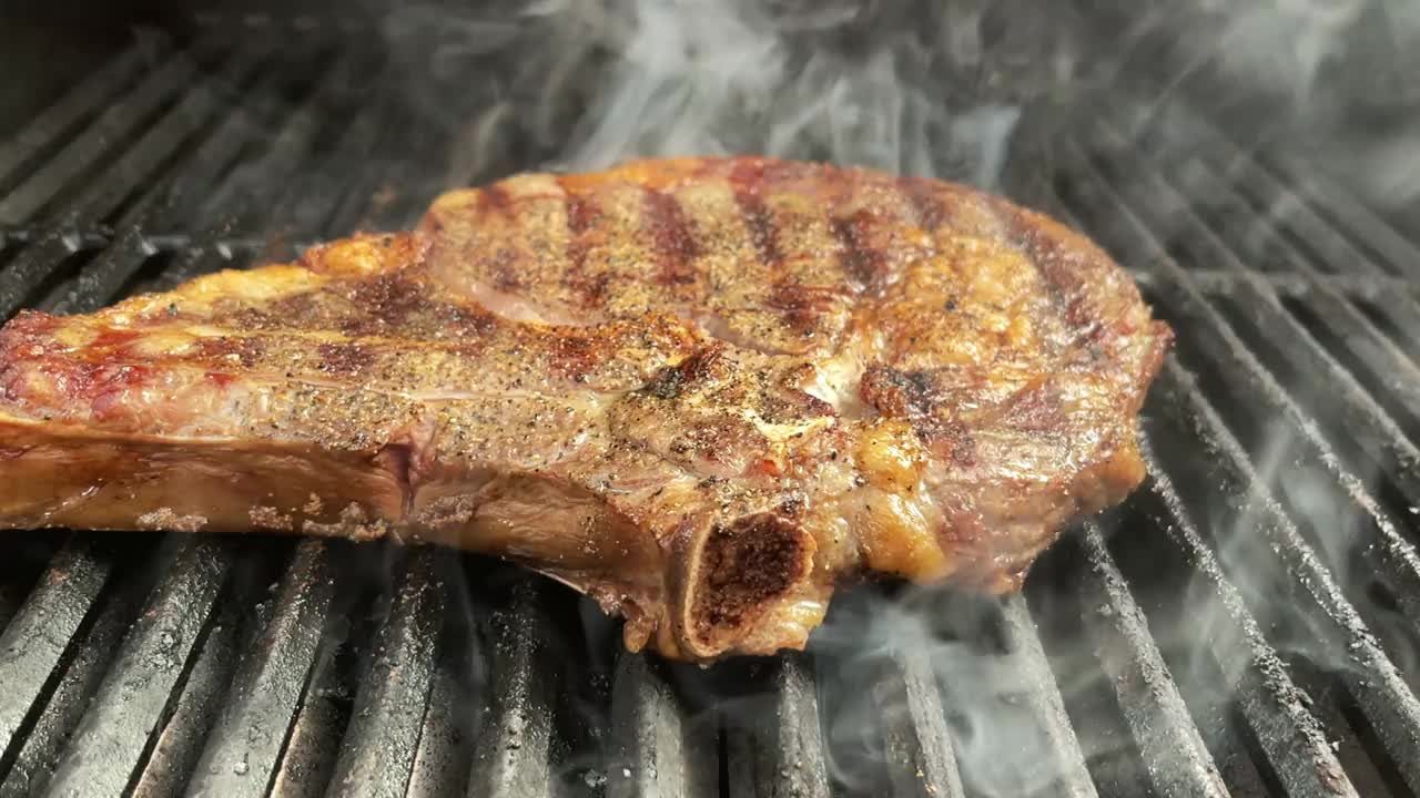厚切生调味牛肉肋眼牛排和有机胡萝卜与火焰木炭烧烤4K视频