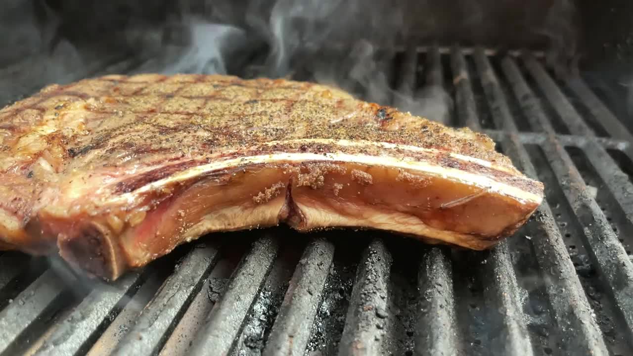 厚切生调味牛肉肋眼牛排和有机胡萝卜与火焰木炭烧烤4K视频