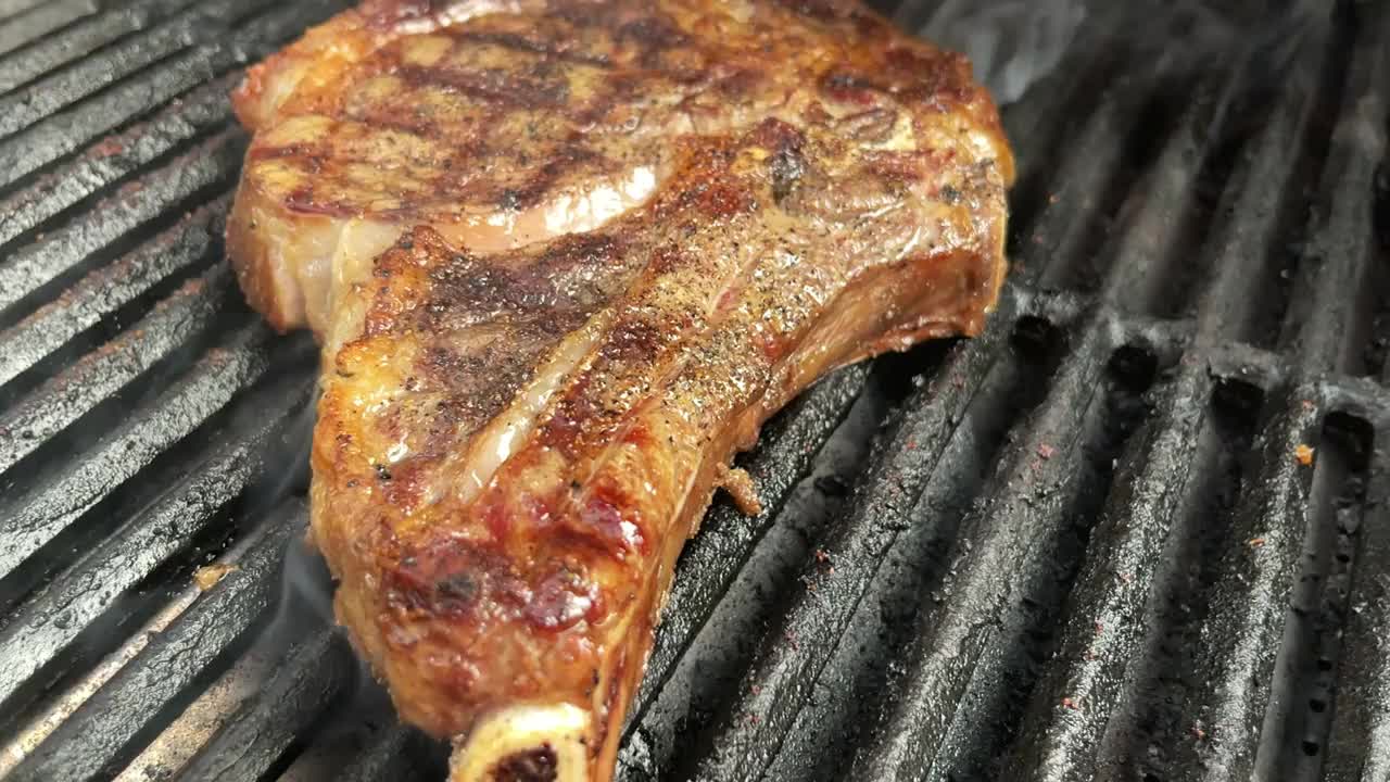 厚切生调味牛肉肋眼牛排和有机胡萝卜与火焰木炭烧烤4K视频