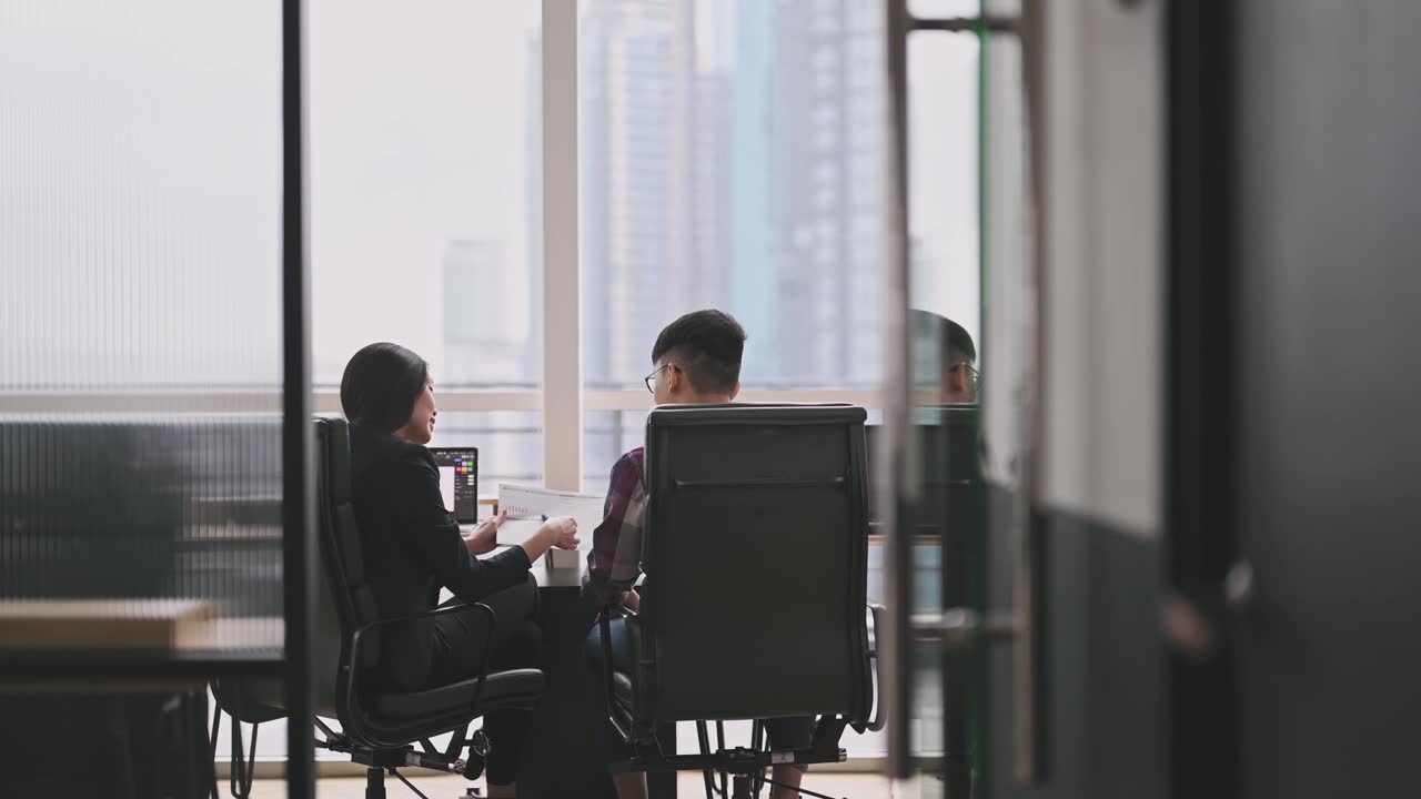 詳情圖-一位亞洲華裔女同事在辦公室向她的學(xué)員解釋