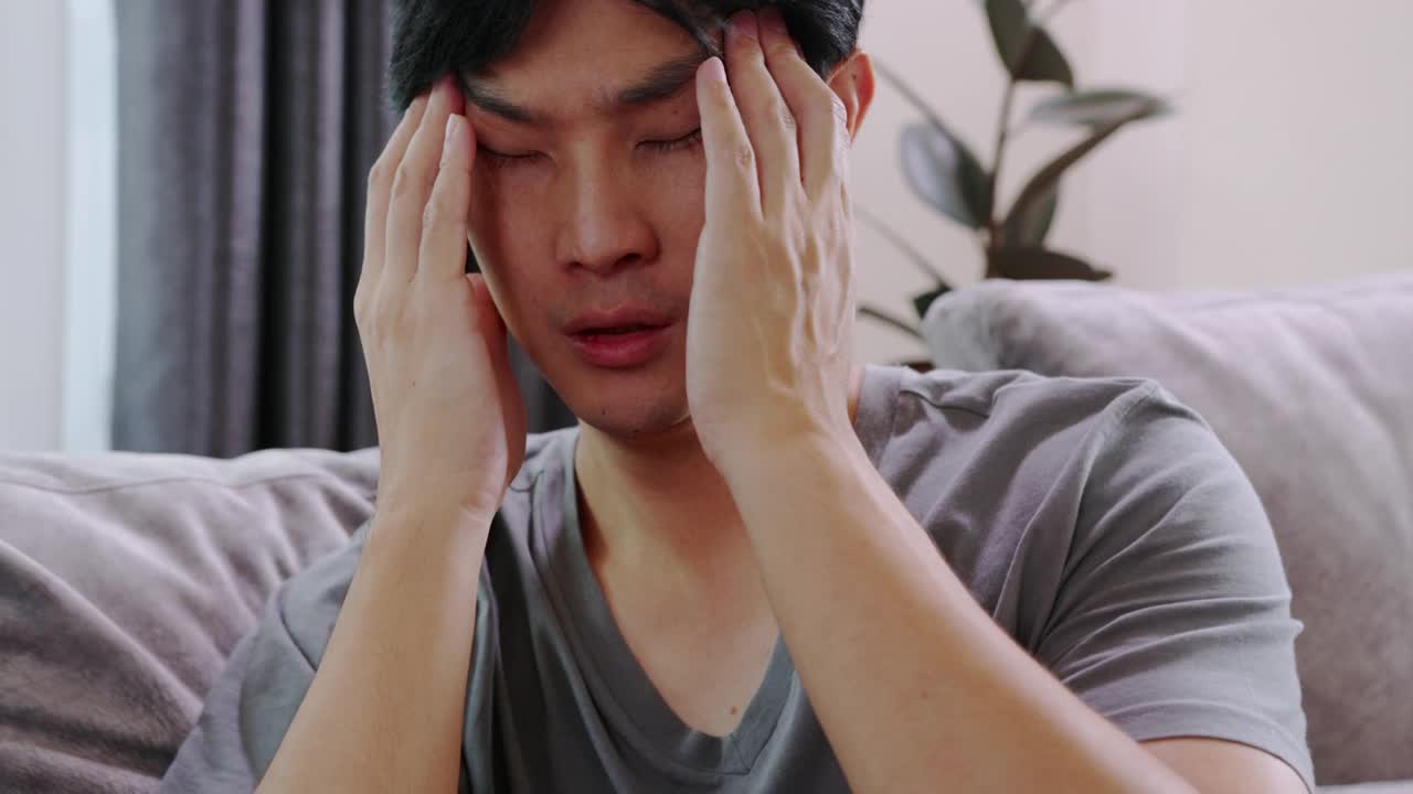 忧郁的亚洲人感冒了。头痛的病毒。