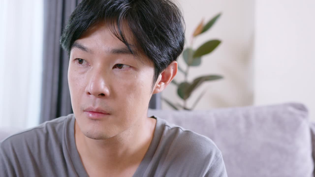 成年男子坐在沙发上，一边喝着维生素和补品。健康的医学