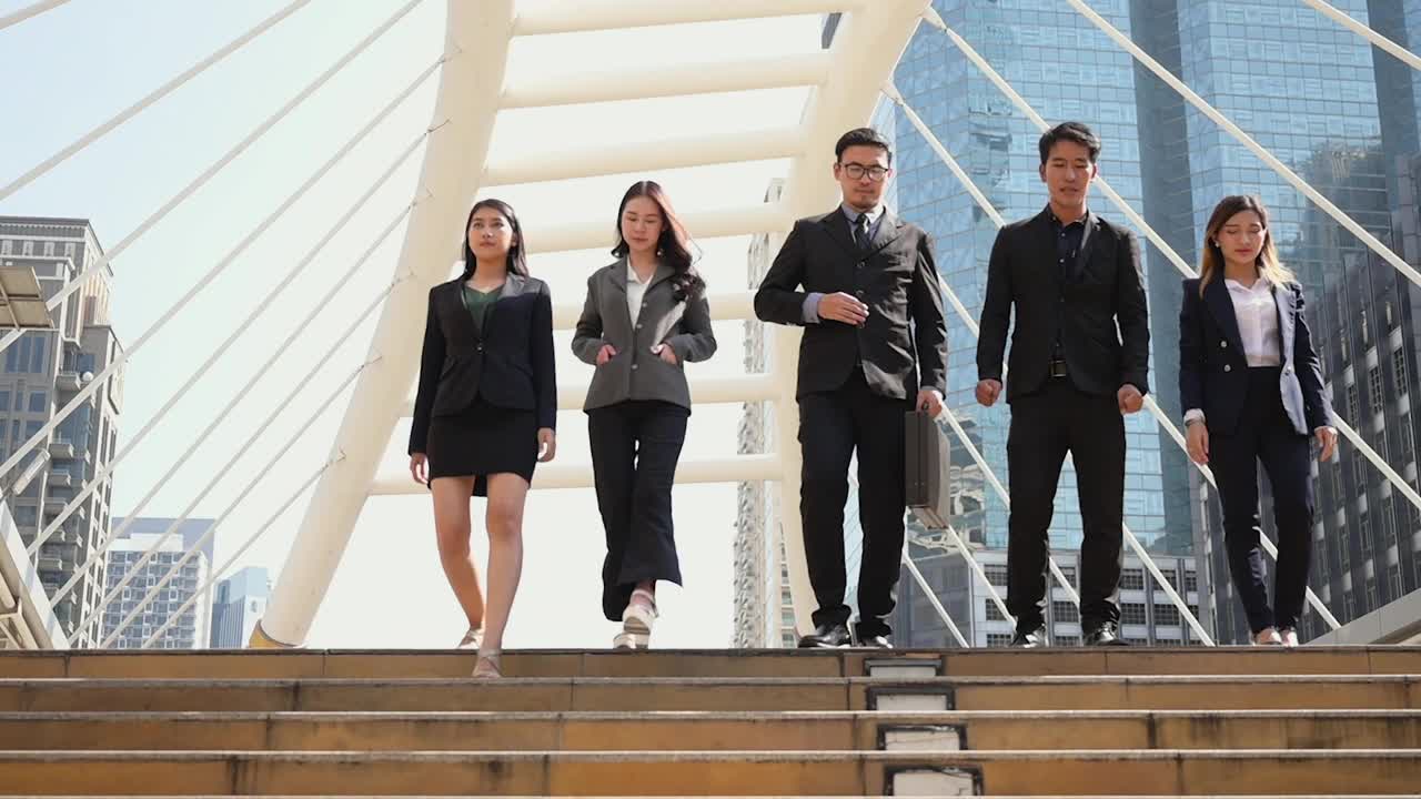 慢动作镜头。一群穿着西装的亚洲商人走下楼梯去上班。