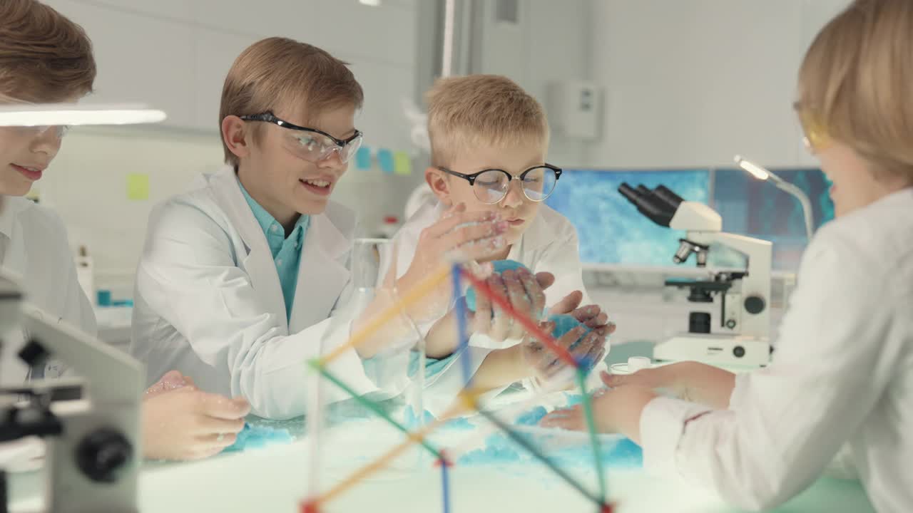 孩子们在实验室里做科学实验。用手制作动粒沙