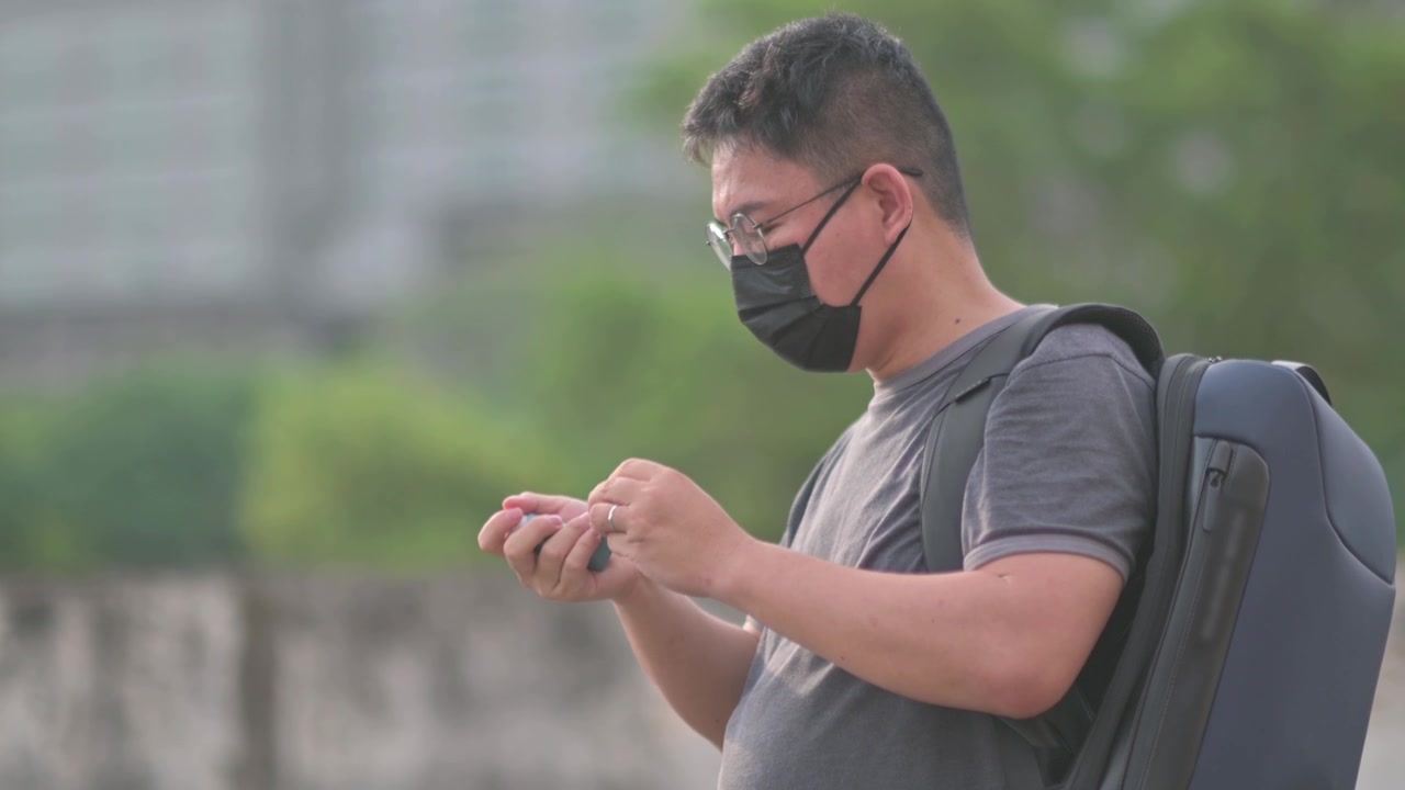 详情图-亚洲华人中年男子戴着口罩，在户外用哮喘吸入器背着背乞讨